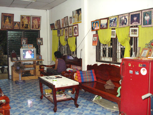 Einfaches Wohnzimmer mit vielen Bildern.