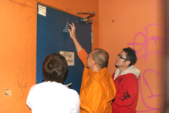 Der Mönch bringt zeremonielle Zeichen an der Aussentür an.