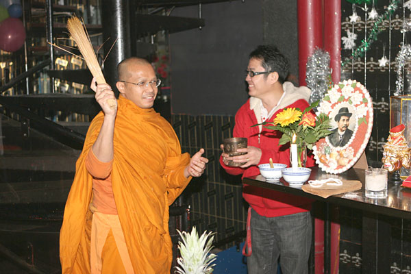 Der Mönch segnet die Räume, Toi hält die Schale mit dem heiligen Wasser.