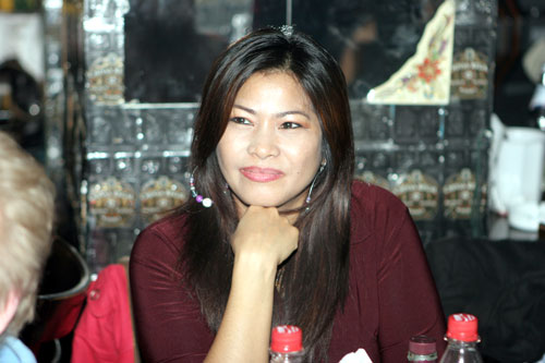 Charmante Thai-Schönheit beobachtet die Party-Szene amüsiert.