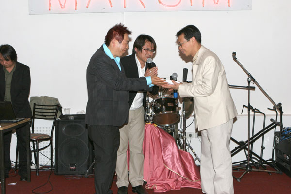 Edd und Yad übergeben die Spenden an den Botschaftsmitarbeiter