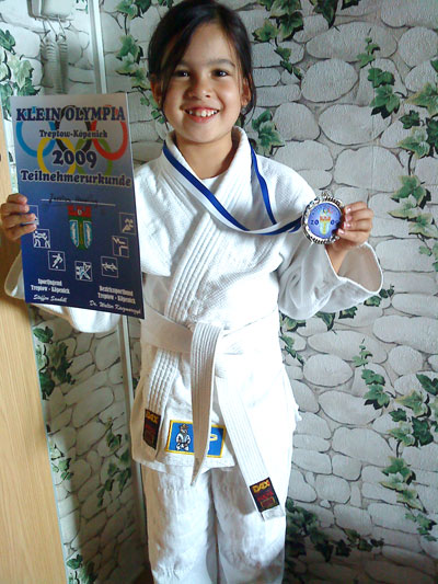 Jessi zeigt stolz ihre Judo-Medaille.