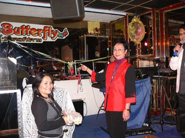 Die Tante eröffnet mit einem Scherenschnitt das neu Thai-Geschäft. Mitinhaberin Jimmy hält eine Schale.